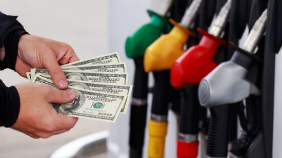 90059738 - dollars in a hands on the background of colorful fuel nozzles